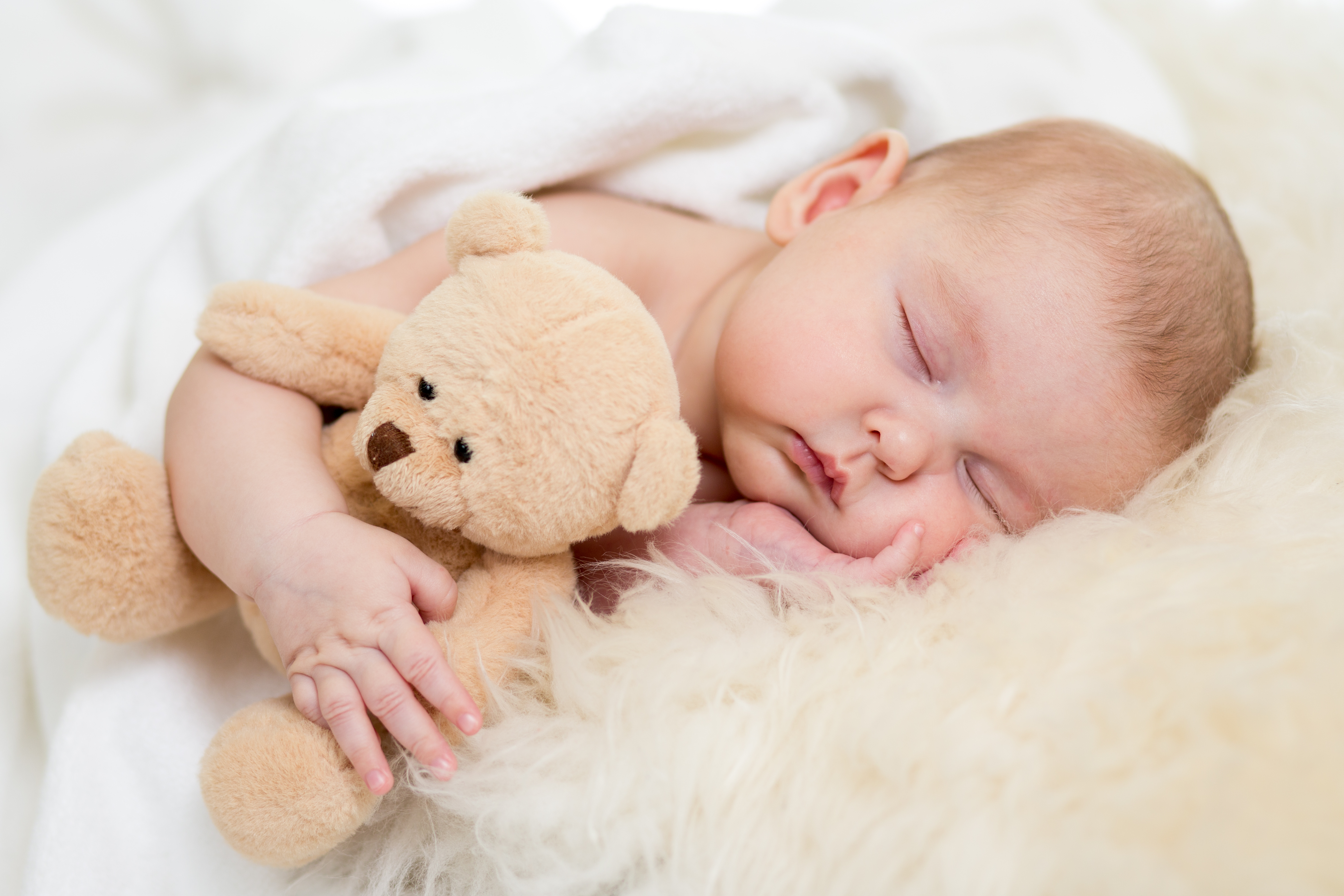 A baby sleeping peacefully beside a teddy bear, the original Ace Cleaners website photograph
